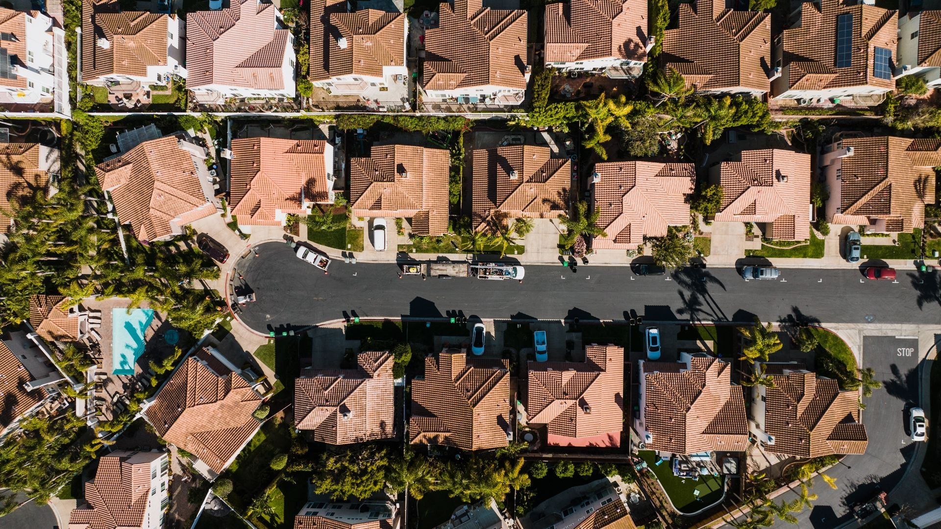 Aerial view of a tile-roofed residential neighborhood with palm trees in Costa Mesa, California
