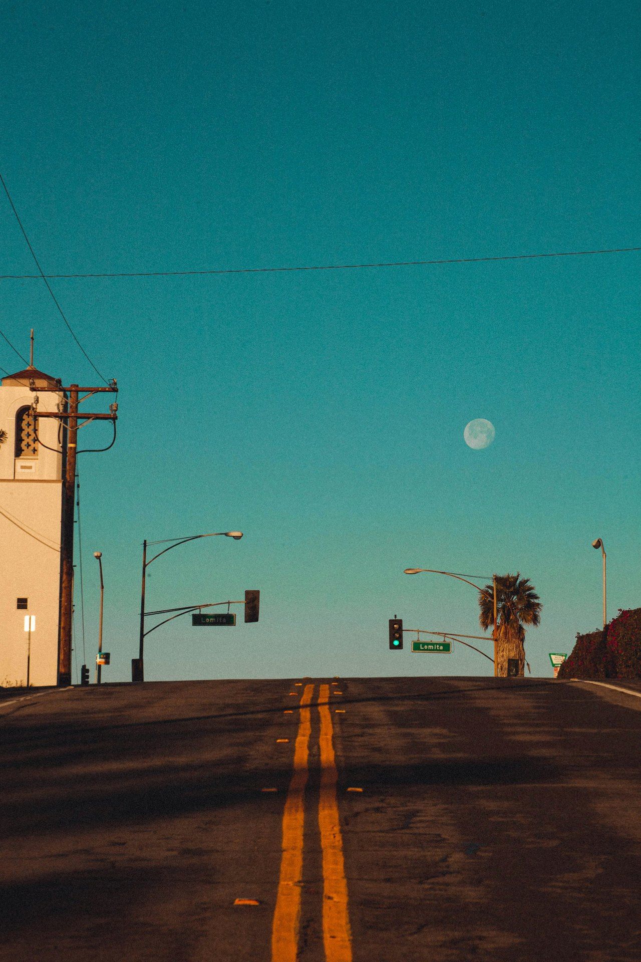 An empty palm-lined street at dawn in El Segundo, California