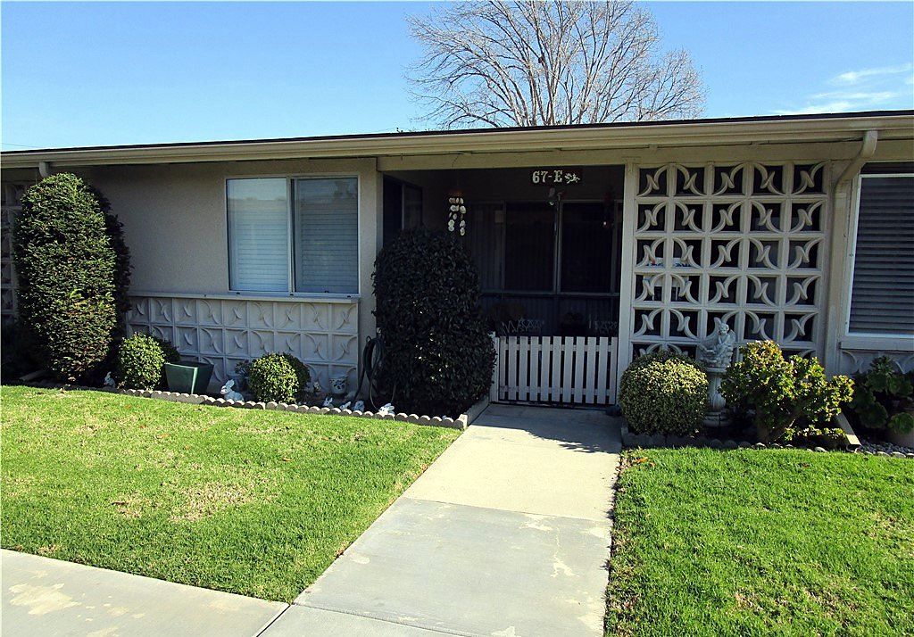 Single-story Leisure World co-op with a decorative breeze-block screen, covered porch and front lawn on Church Place in Seal Beach, California