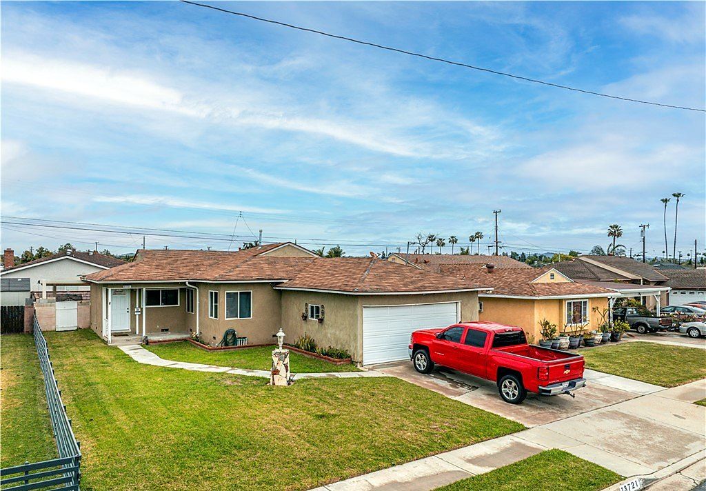 Single-story ranch home with a brown roof, white garage door and a wide front lawn on Placid Drive in East Whittier, California