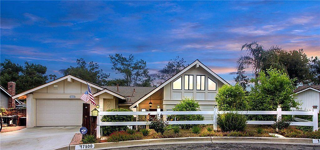 Single-story Yorba Linda home with a white rail fence and mature trees at sunset, sold by The Chavez Team