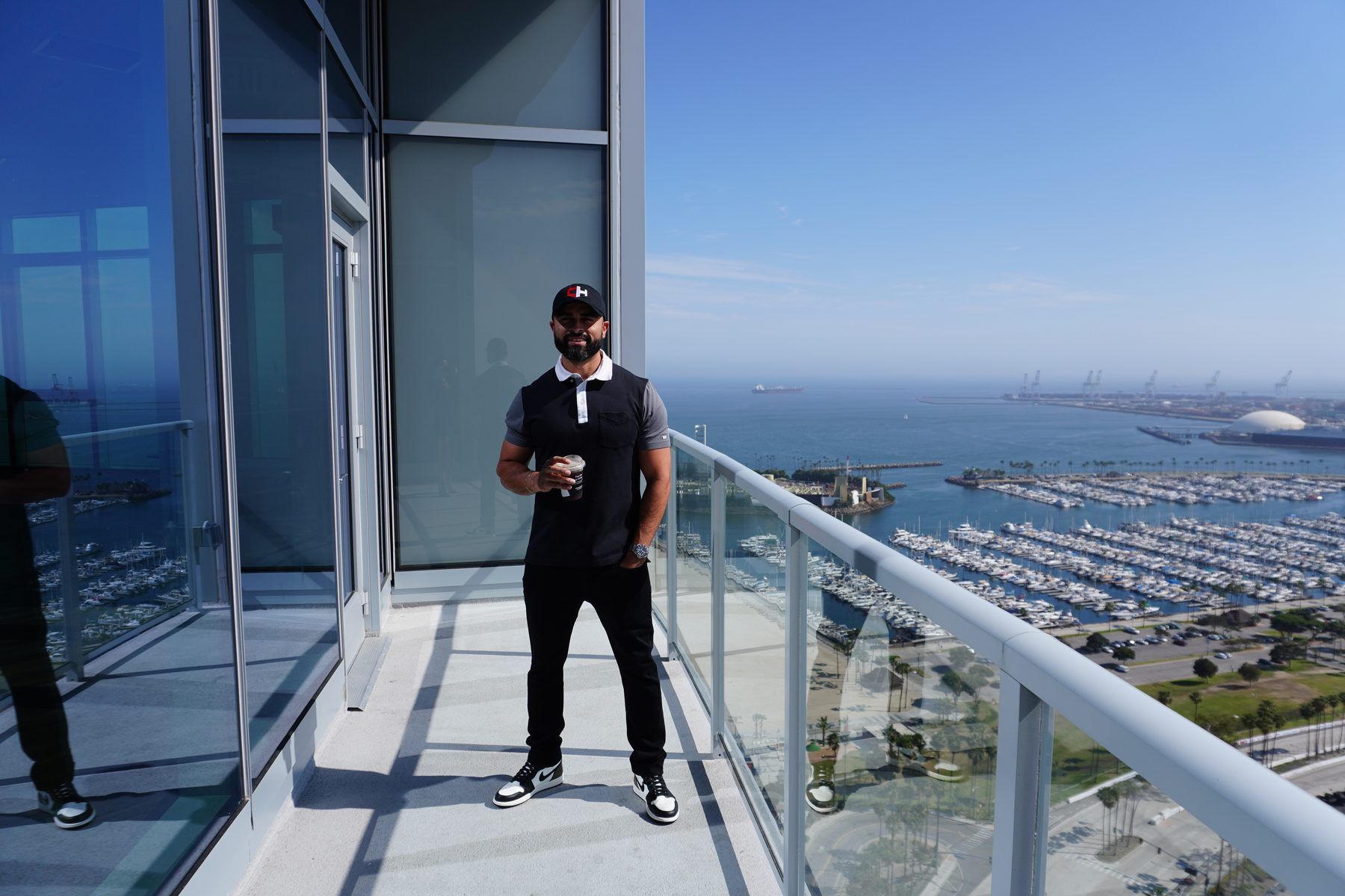 Ismael Chavez on a high-rise balcony overlooking the Long Beach marina