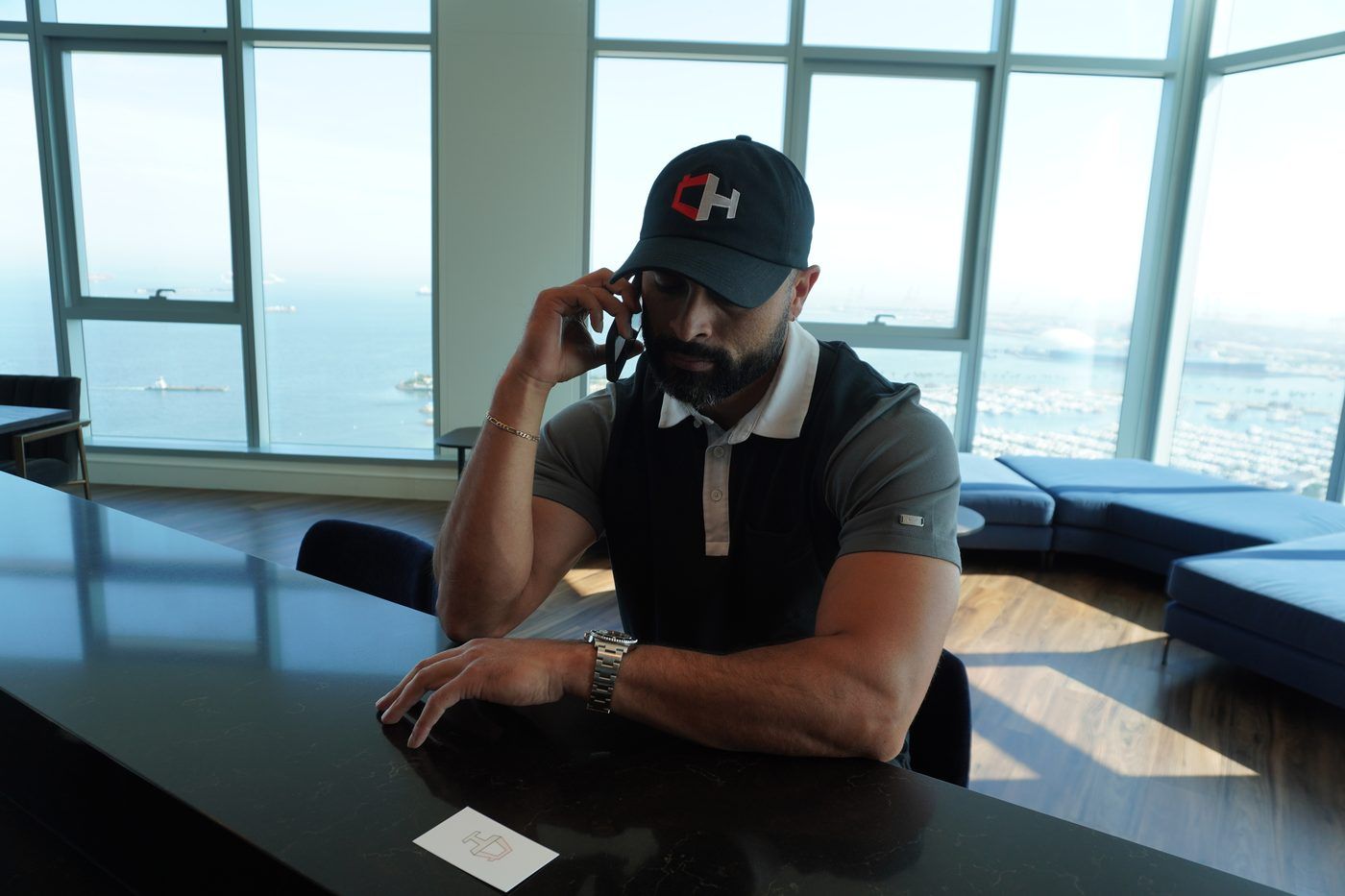 Ismael Chavez on the phone at a window desk above the Long Beach harbor