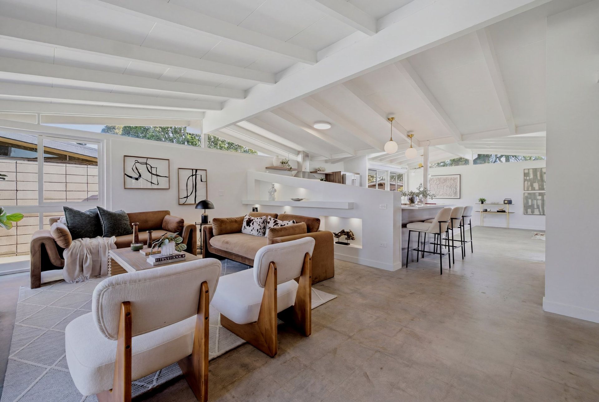 Open living and dining room at 3062 Lees Ave, a 1954 Cliff May Rancho in Long Beach — white post-and-beam ceiling and a wall of glass opening to the patio — listed by The Chavez Team at The Agency