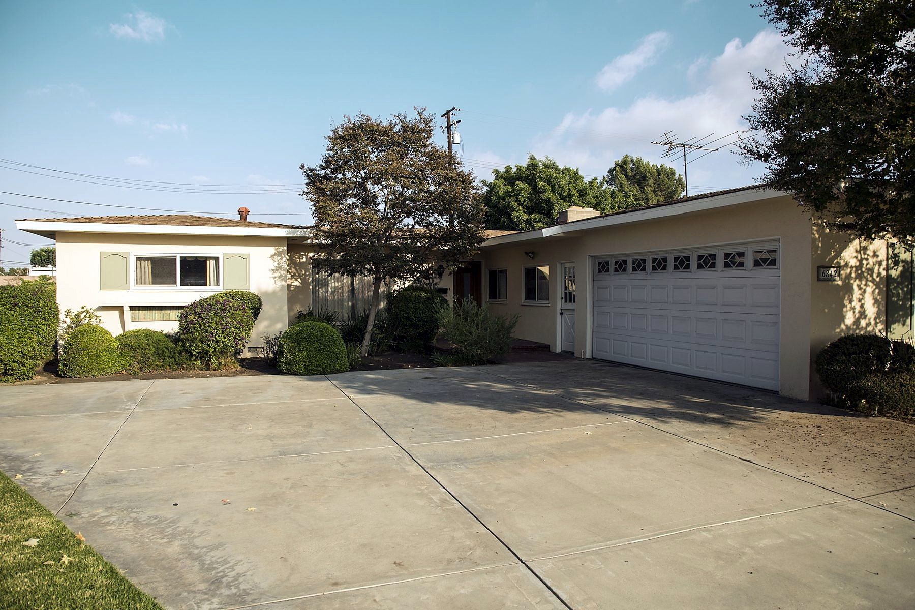 Single-story ranch home with a wide concrete driveway and two-car garage in Cypress, California