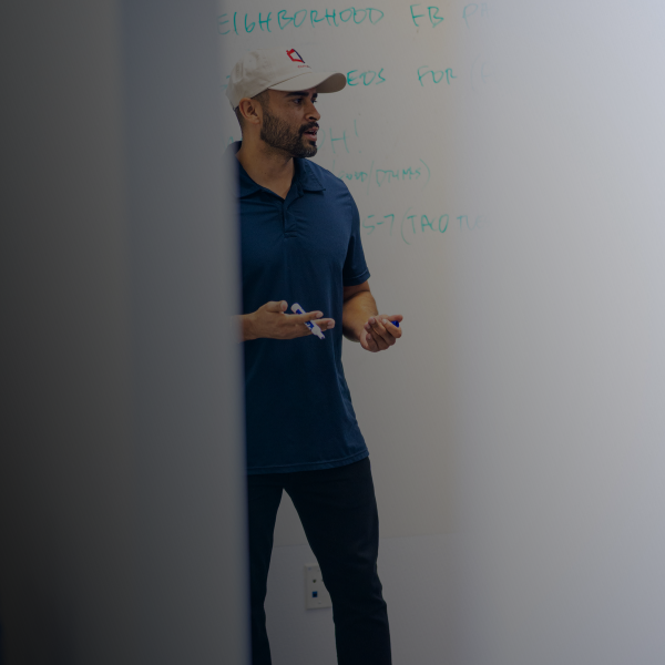 Ismael chavez talking to team writing on a white board